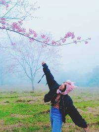 Full length of man standing by tree on field