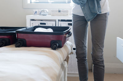 Low section of woman standing on bed