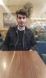 Portrait of young man sitting in restaurant