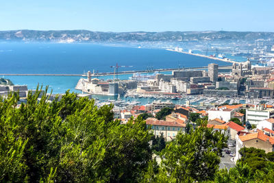 High angle view of townscape by sea against sky