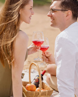 Side view of smiling couple holding wineglass outdoors