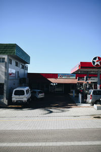 Cars on street against clear blue sky