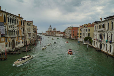 Boats in canal amidst buildings in city