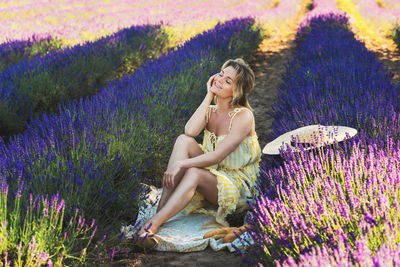 Portrait of young woman sitting on field