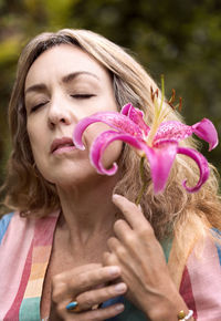 Woman with pink lily in her hands