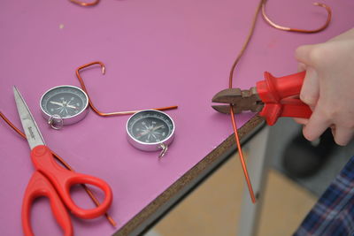 High angle view of hand holding clock on table