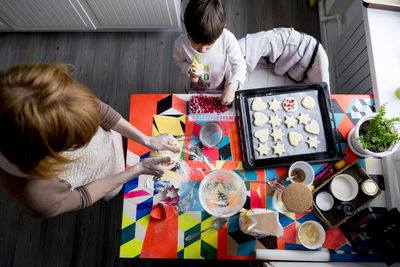 Overhead view of mother and son making cookies at home