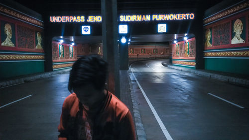 Rear view of woman on road at night