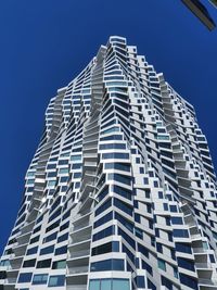 Low angle view of modern building against clear blue sky