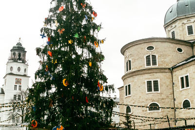 Low angle view of trees and building against sky