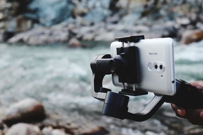 Close-up of hand holding smart phone on monopod