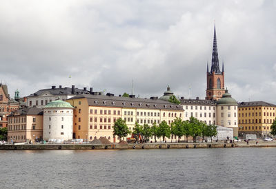 Buildings in city against cloudy sky