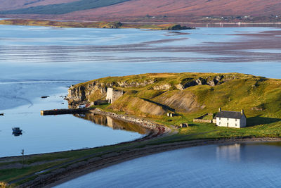 Scenic view of lake with house and jetty on island in scotland