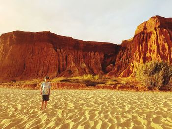 Rear view of man walking on rock