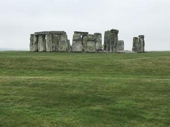 Stonehenge on grass against sky