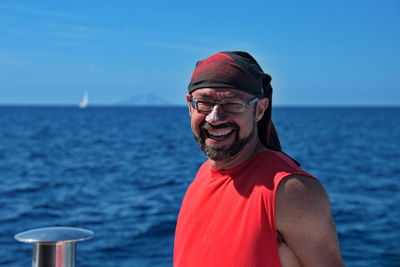 Portrait of smiling man in sea against sky