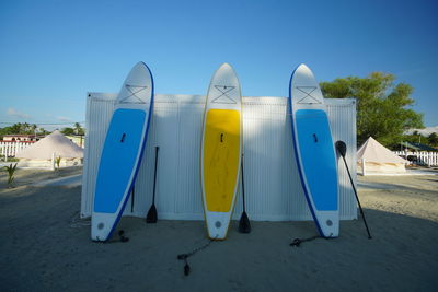 Deck chairs on beach against blue sky