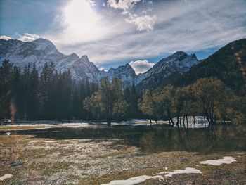 Scenic view of lake by mountains against sky