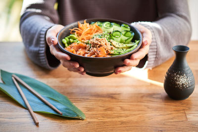 Midsection of woman holding food on table