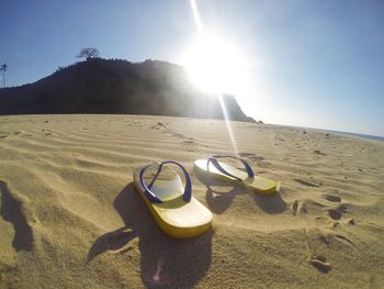 Bicycle on sand at beach against sky