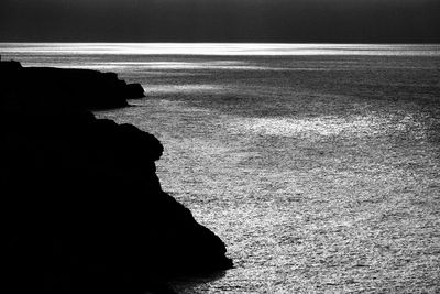 Rock formation on beach against sky