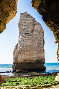 Rock formations by sea against sky