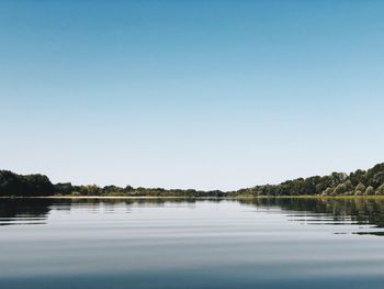 Scenic view of lake against clear blue sky