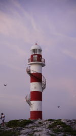 Low angle view of lighthouse by sea against sky