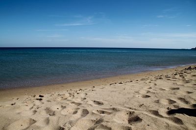 Scenic view of beach against blue sky