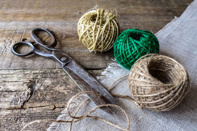 High angle view of scissors and ball of wool on table