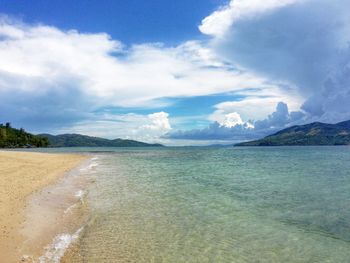 Scenic view of beach and sea against cloudy sky