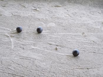 High angle view of marble balls on sandy field