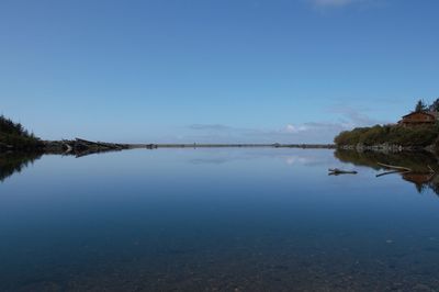 Scenic view of lake against clear blue sky