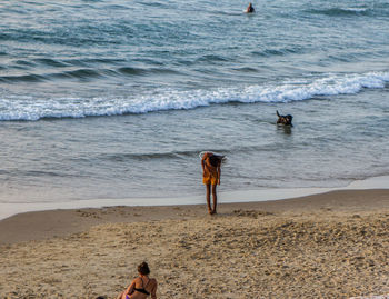 Woman standing on beach against sea