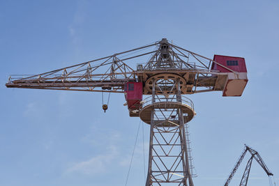 Low angle view of crane against sky