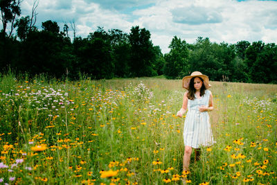 Full length of woman standing on field against sky