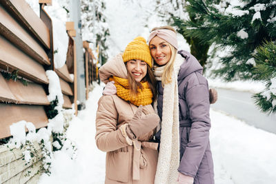 Portrait of smiling young woman standing in snow