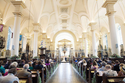 People sitting in church during wedding ceremony