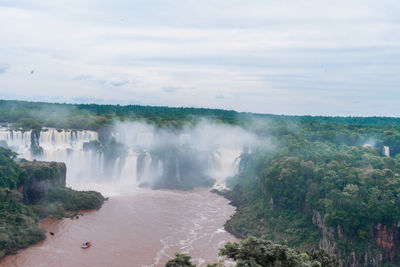 Scenic view of waterfall against sky