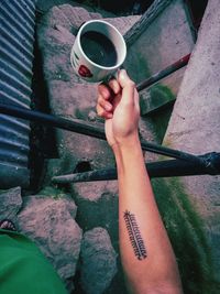 Cropped hand holding coffee cup