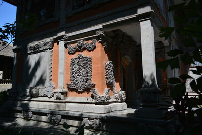 Low angle view of cross hanging outside building