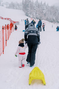 People walking on snow covered landscape