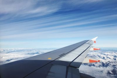 Close-up of airplane wing against cloudy sky