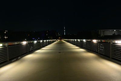 Illuminated bridge amidst buildings in city at night