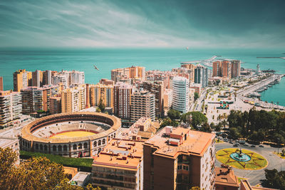 High angle view of buildings and sea against sky