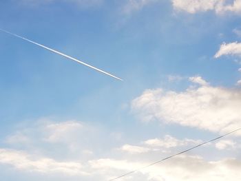 Low angle view of vapor trail against blue sky