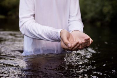 Midsection of man standing in river