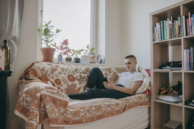 Woman sitting on sofa at home