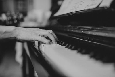 Close-up of hand playing piano