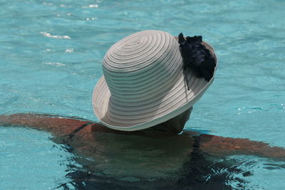 Rear view of person with hat in swimming pool